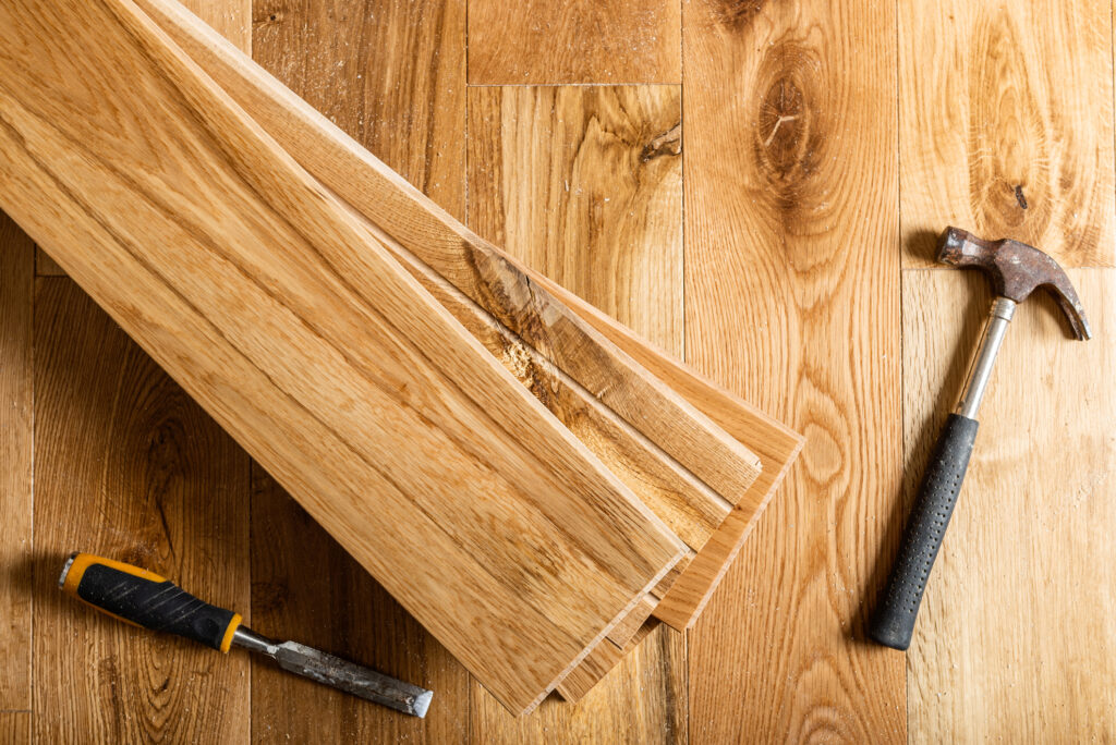 Leftover hardwood boards next to a hammer and chisel.